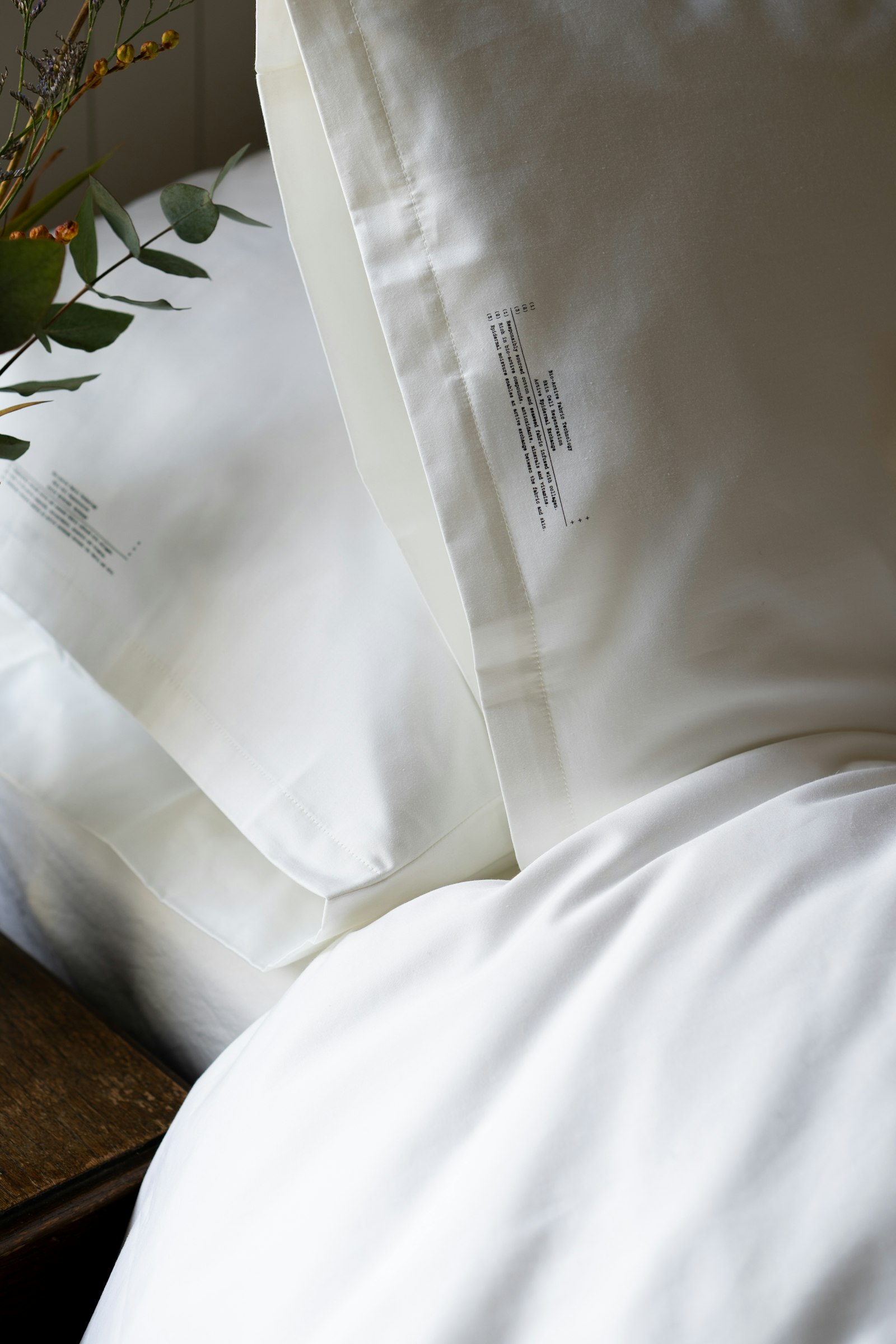 Frisch bezogenes weißes Bett mit gestapelten Kissen